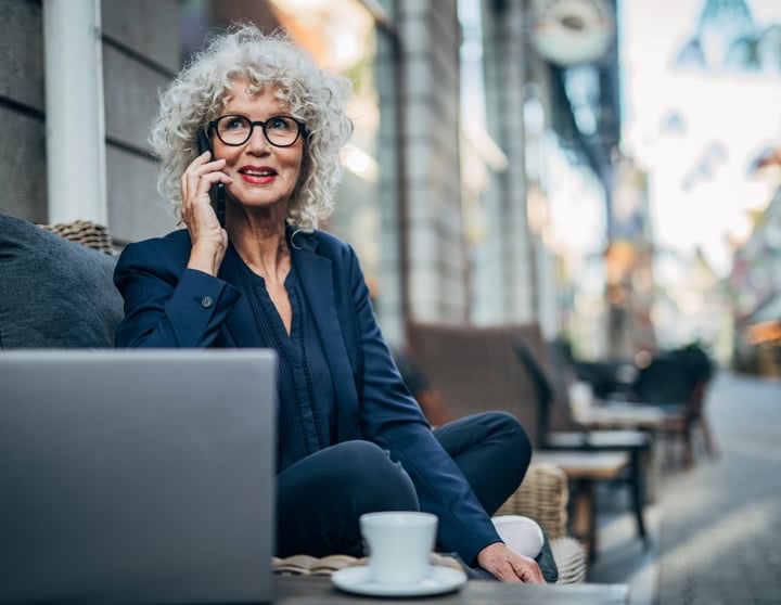 Mevrouw zit achter haar laptop en is aan het bellen