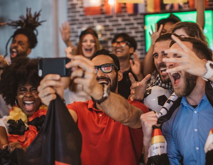 Een grote groep vrienden kijkt samen naar het EK voetbal 2024