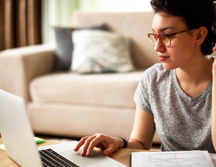 A young woman is researching the topic of insolvency proceedings on her laptop computer.