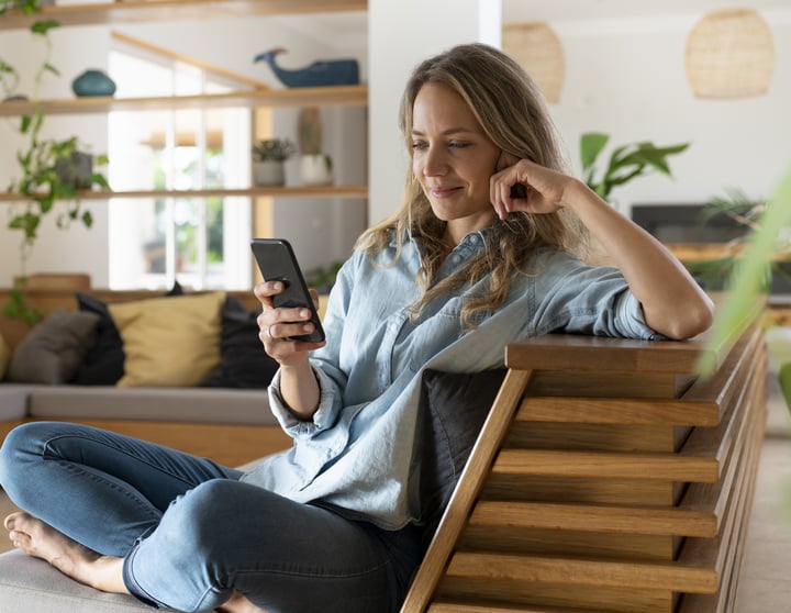 Frau, die ihr Mobiltelefon benutzt