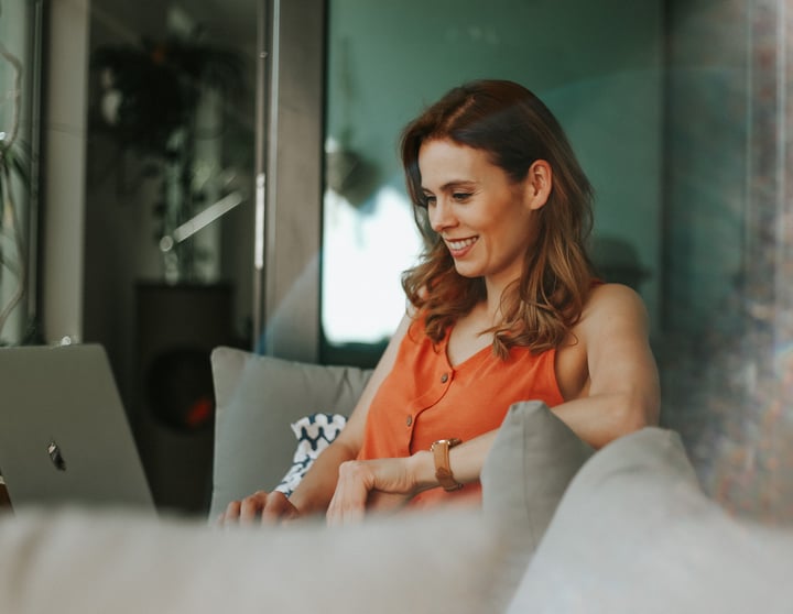 Een vrouw leest op haar laptop tips voor het verlagen van haar belasting