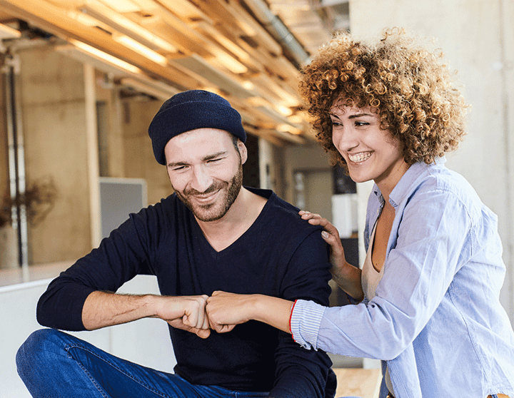 Frau und Mann treffen freundschaftlich mit Händen gegeneinander