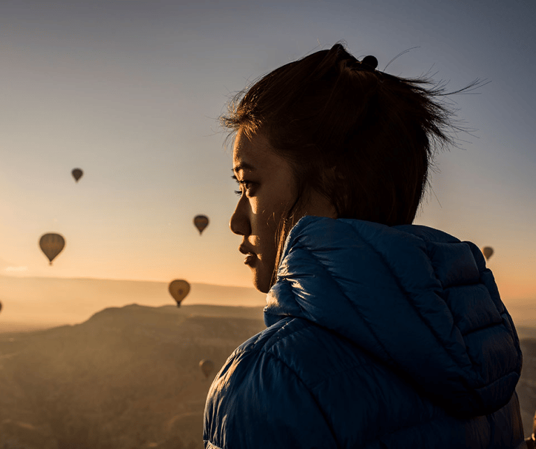 Frau im Freien mit Heißluftballons am Himmel