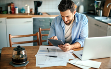 A man with a blue shirt is checking his finances