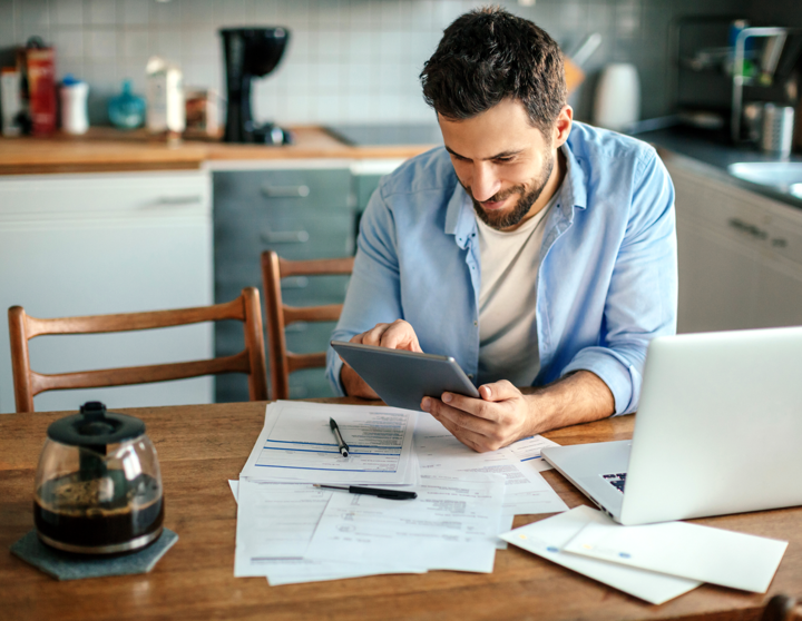 The image shows a young man who is checking his finances