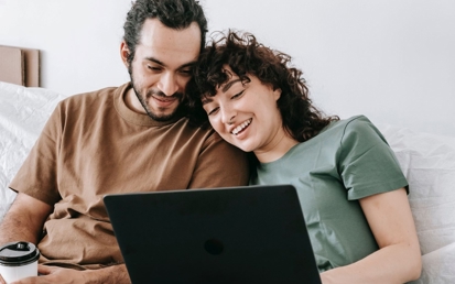 lykkelig par foran en bærbar datamaskin
