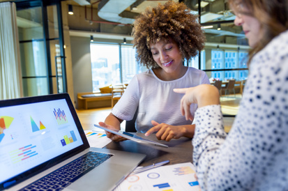two girls in front of a laptop
