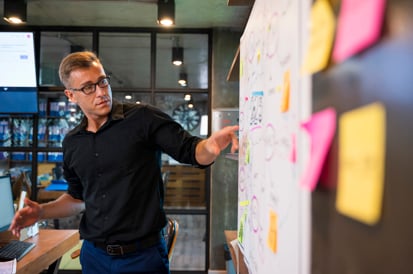 young man in front of a white board