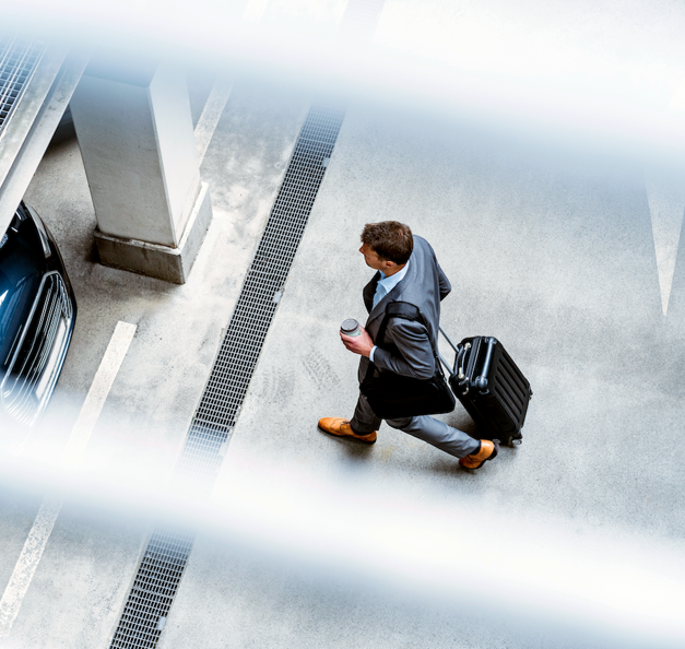 Mies kävelee kohti autoaan pysäköintialueella