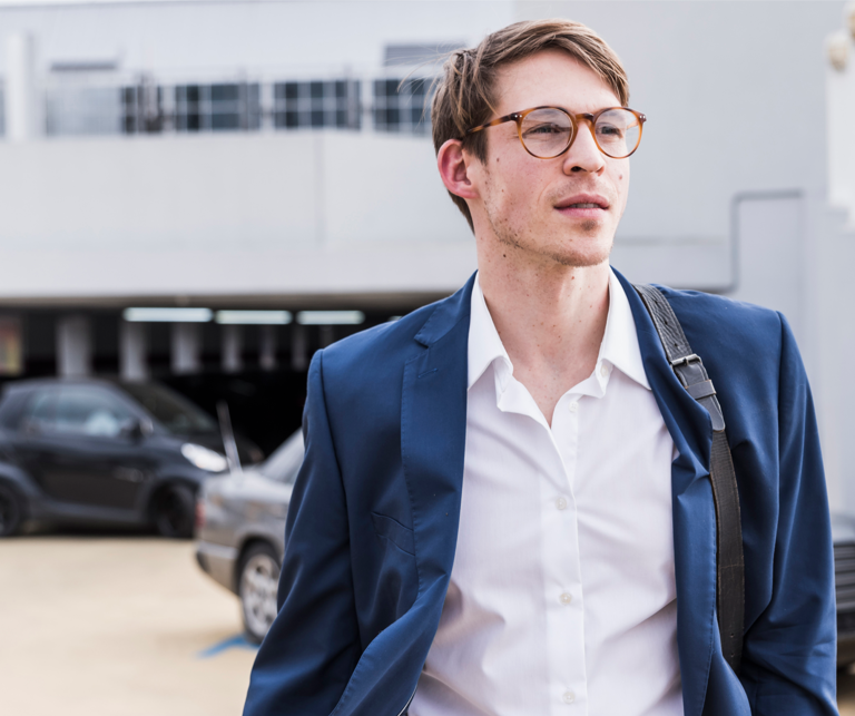 Mann mit blauer Jacke, Parkplatz im Hintergrund