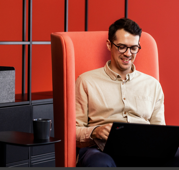 Man sitting in a modern office environment and working on his laptop.