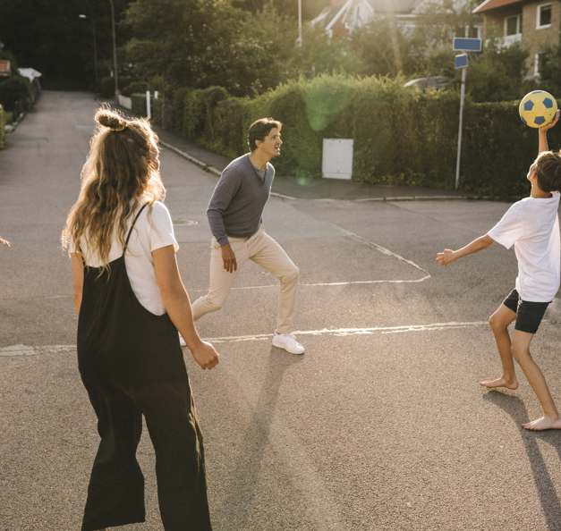 Family playing outside with a ball.