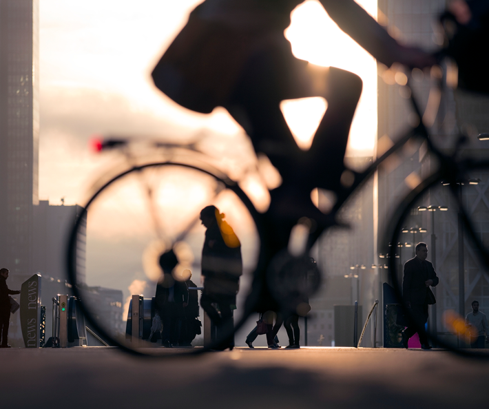 Silhouette eines Fahrradfahrers im abendlichen Licht einer Großstadt