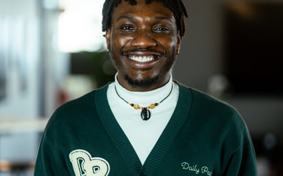 Ein Bild von Timothy. Er hat kurze Haare und trägt eine dunkelgrüne Jacke.